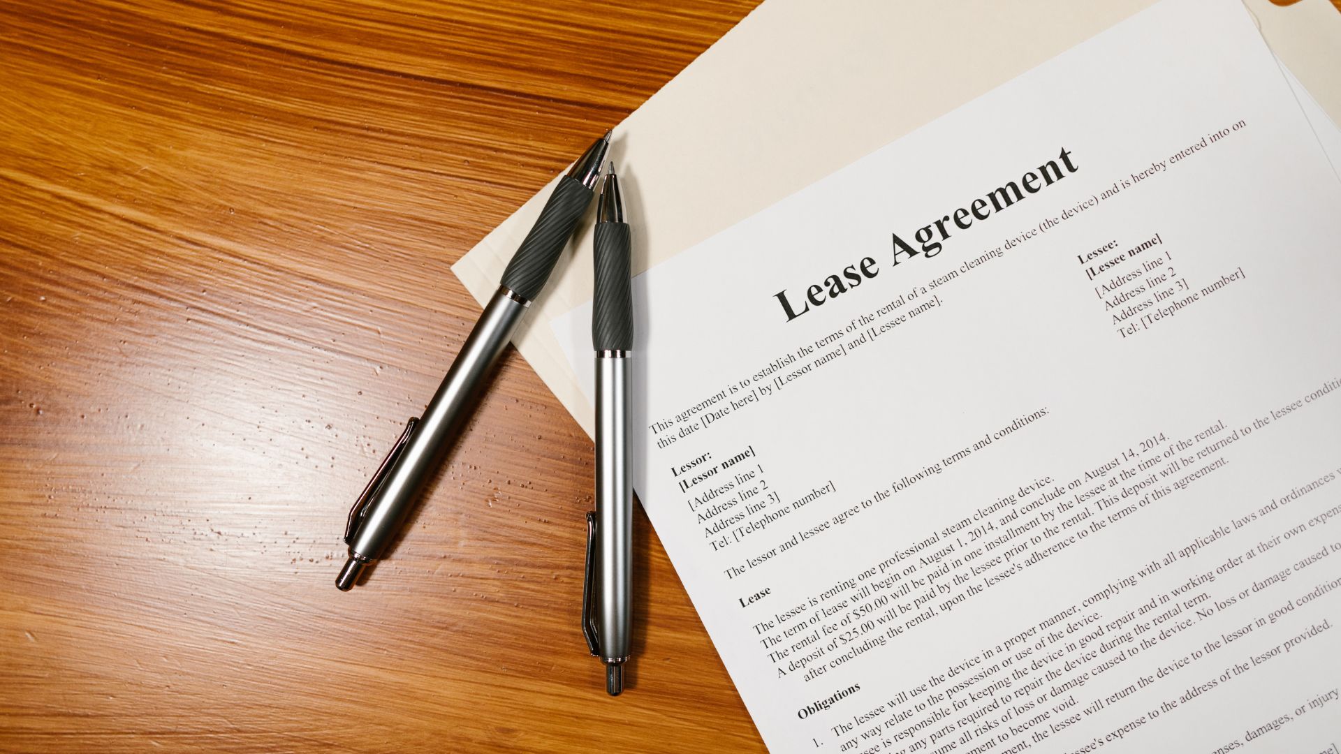 Website%20Dev.%20-%202025-07-02T154440.691 lease agreement on a desk with two pens